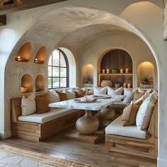 a living room filled with lots of furniture next to an arched wall and window covered in windows