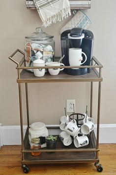 a coffee bar cart with cups and mugs on it