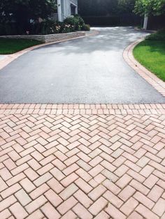 a red fire hydrant sitting on the side of a brick road in front of a house