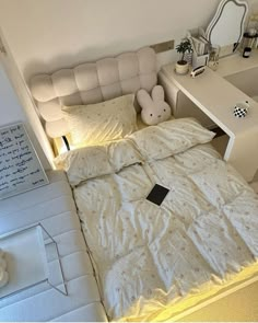 a white bed sitting in a bedroom next to a desk