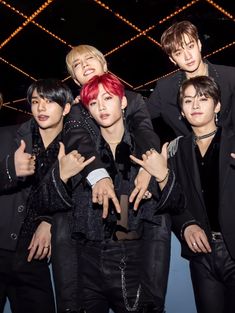 group of young men posing for the camera with their hands up in front of them