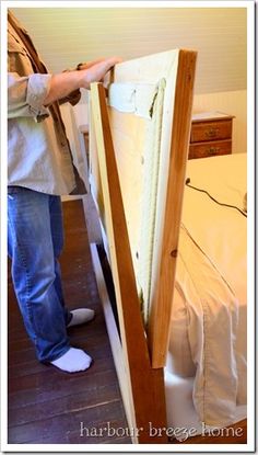 a person standing in front of a bed with a mattress on it's side