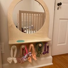 a baby's room with a mirror and toys on the shelf