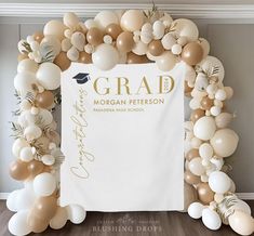 an arch made out of balloons with a graduation cap and diploma on the front banner