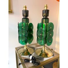 two green glass lamps sitting on top of a table