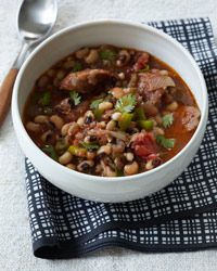 a white bowl filled with beans and meat