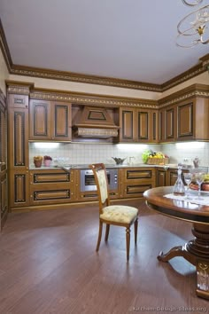 a large kitchen with wooden floors and brown cabinetry, along with a round dining table surrounded by two chairs