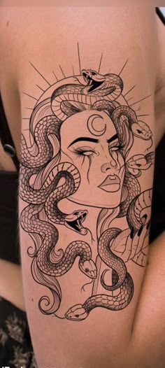 a woman's thigh with a tattoo design on her leg and an image of a snake