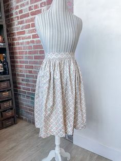 a dress on a mannequin in front of a brick wall