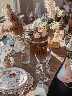 the table is set with dishes and vases