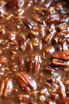 pecans and other nuts are mixed together in the chocolate sauce on top of each other