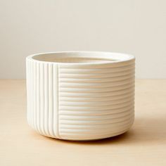 a white bowl sitting on top of a wooden table