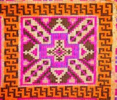 an orange, pink and brown rug with geometric designs on it's edges is shown