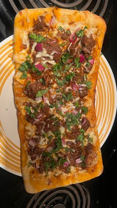 a pizza sitting on top of a white and yellow plate