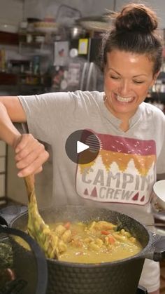 a woman cooking food in a pot on the stove