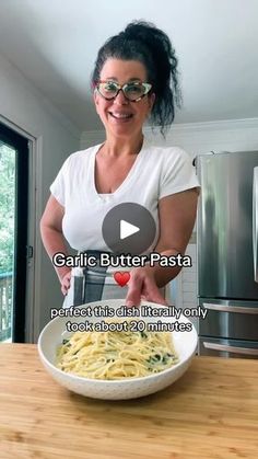 a woman is making pasta in her kitchen with the words garlic butter pasta on it