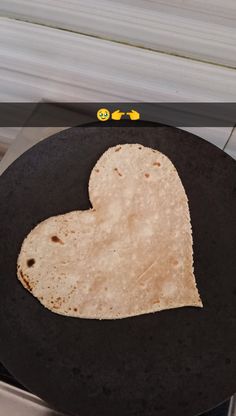 a heart shaped tortilla on a black plate