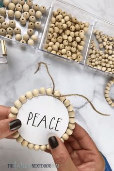 a person holding a bead with the word peace on it in front of some beads