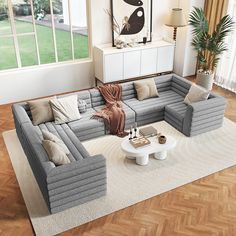 a living room filled with furniture on top of a hard wood floor covered in white rugs