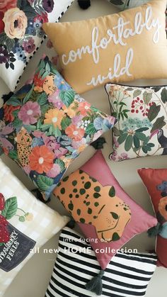 many pillows are arranged on the floor with different designs and colors, including flowers or leaves