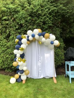 a balloon arch with gold and white balloons