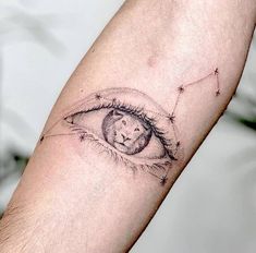 a tattoo on the arm of a man with an eye and cat's face