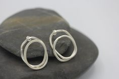 "These earrings are a part of our latest collection called \"scribbles\". They are made of a continuous silver wire that was wrapped and curved to create the final shapes of a double infinity loop. They were created from a square-profile 2 mm silver wire, in 95%silver, that was etched on the surface to give it a more handmade, artisan-crafted feel. The posts and stoppers are in sterling silver. In the same collection there are three more earring designs, created in a similar way. All our silver Double Infinity, Unique Studs, Stud Earrings Unique, Earring Designs, Silver Rings Handmade, Buy Handmade, Handmade Artisan, Tibet, Silver Wire