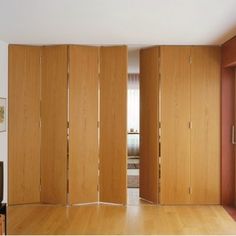 a room divider made out of wood with sliding doors on each side and an open door in the middle