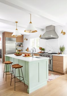 a kitchen with two stools in front of the island and an oven on the other side