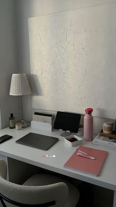 a white desk with a laptop, lamp and other office supplies on top of it