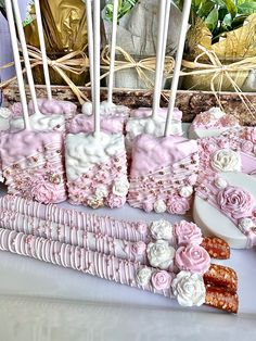 pink and white wedding cake with flowers on it sitting on a table next to candles