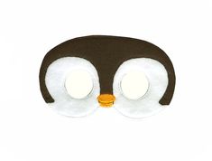 a close up of a penguin mask on a white background with one eye open and two eyes closed