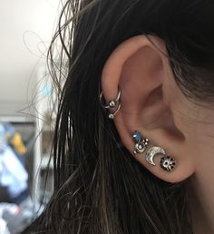 a woman with three ear piercings on her ears and one has a skull in the middle