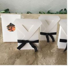 three white boxes with black ribbon tied around them