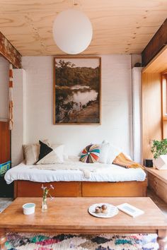 a bed room with a neatly made bed and coffee table