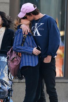 a man and woman kissing on the street