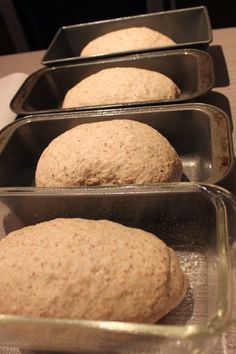 three metal pans filled with bread on top of a table