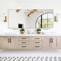 a bathroom with two sinks and a large mirror on the wall next to a rug