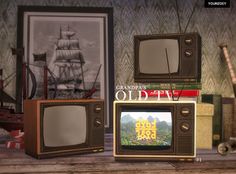 three old tvs sitting on top of a wooden table