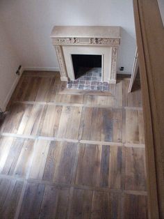 an empty room with a fireplace and tiled floor in the corner, viewed from above