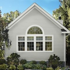 a house with white windows and landscaping around it