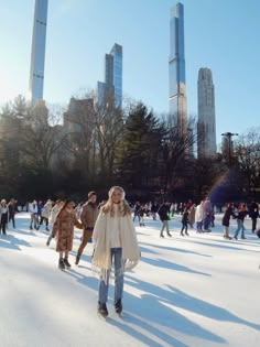 people skating on an ice rink with skyscrapers in the background