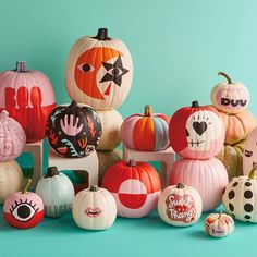 a group of pumpkins sitting on top of each other in front of a blue background