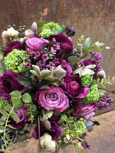 a bouquet of purple flowers sitting on top of a table