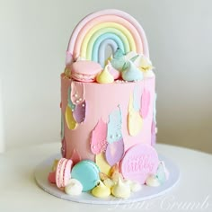 a birthday cake decorated with pastel colors and rainbows