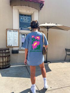 a woman standing in front of an ice cream shop with her back to the camera