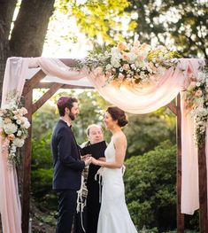 a man and woman standing under a wedding arch