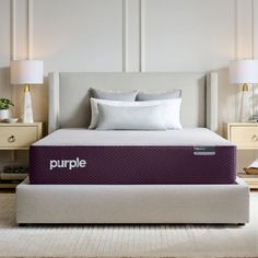 a purple mattress sitting on top of a bed next to two nightstands and lamps