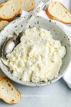 a bowl filled with cottage cheese next to slices of bread