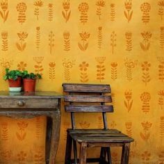 two wooden chairs sitting in front of a table with a potted plant on it